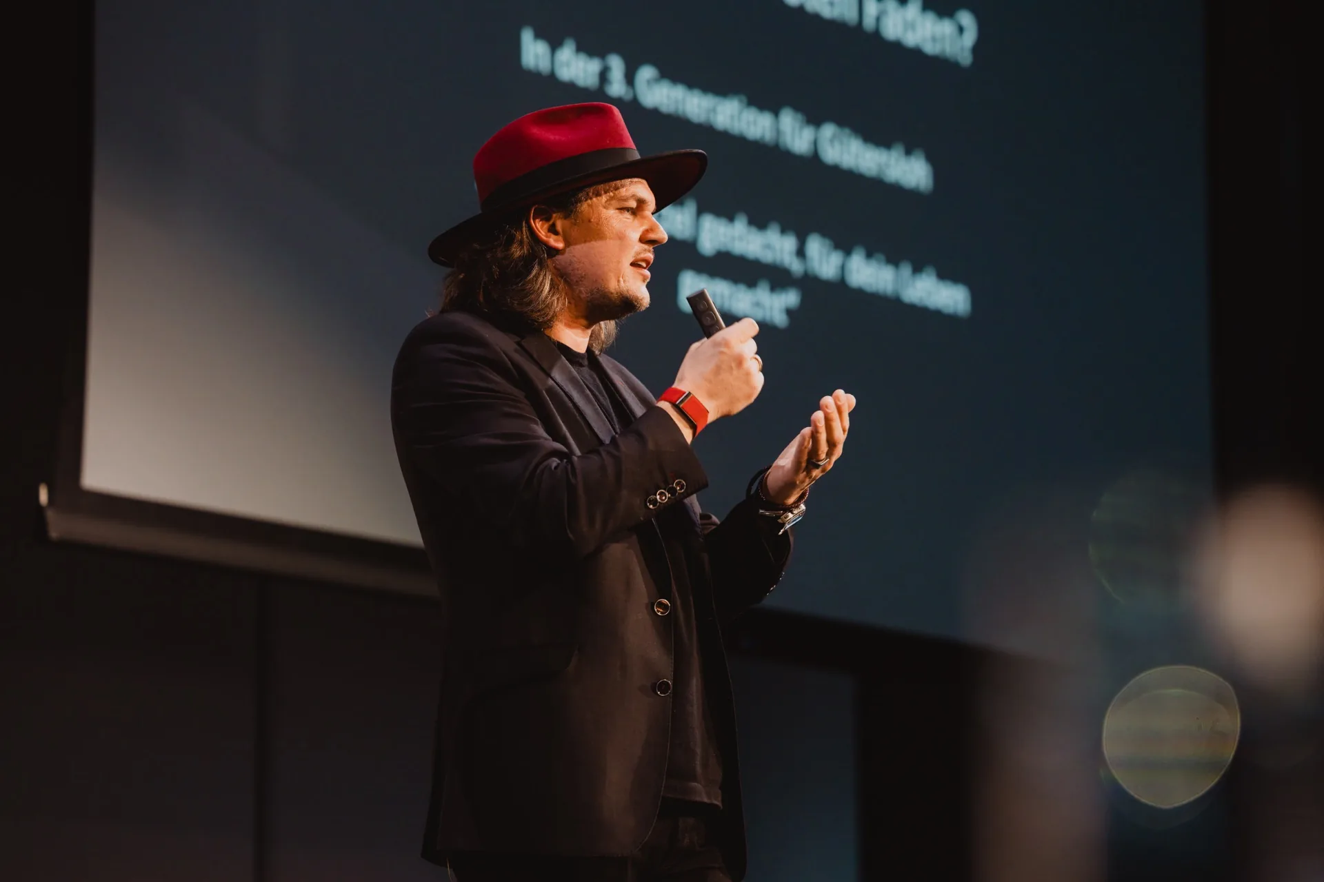 Speaker mit rotem Hut auf der Bühne der DENTALEN THEMENWELT